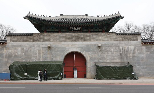 19일 오후 서울 종로구 경복궁 영추문에 스프레이 낙서로 훼손된 담벼락 복구 작업을 위한 가림막이 설치돼 있다.  연합뉴스